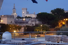 Sommerabend auf dem Sonnendeck der A-Rosa Stella bei der Abfahrt aus Avignon – beleuchtete Silhouette der Stadt auf Etappe 8 unserer Flussreise Lyon–Mittelmeer 2025