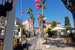 Côte d’Azur Reise Grasse – Start der Stadtrundfahrt mit dem Petit Train am Place du Cours Honoré-Cresp. Le Petit Train. Rote Regenschirme