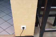 E-Bike-Akku steckt in Tankstelle an Steckdose zum Laden