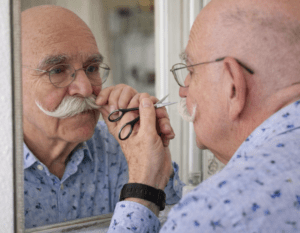 Werner Deck schneidet sich vorsichtig selbst den Bart vor dem Spiegel