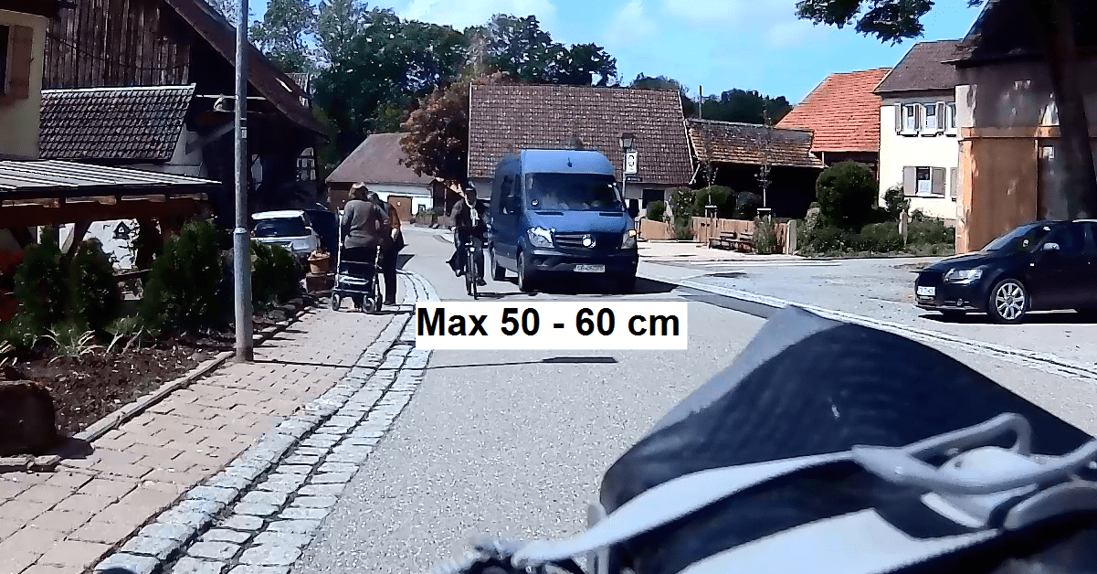 Transporter nähert sich zwei Radfahrern in einem Dorf – gefährlich geringer Überholabstand von nur etwa 50 bis 60 Zentimetern